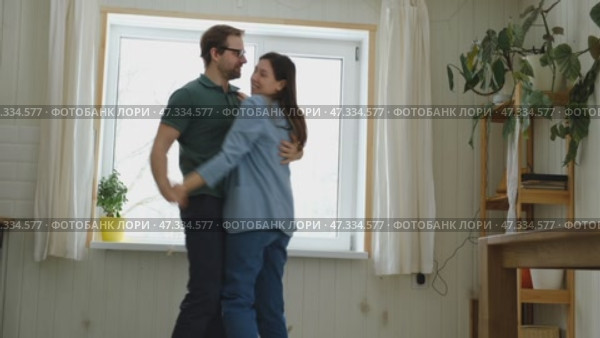 Emotional Dance. Middle-aged Couple Dancing Together Embrace at Home. Mature Couple dancing bonding, smiling and moving to the rhythm in a romantic vibe enjoying their anniversary. Active relationship. Стоковое видео, видеограф Марина Демидюк / Фотобанк Лори