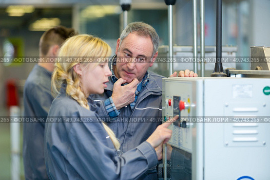engineer and apprentice using computerized cutting machine. Стоковое фото, агентство Ingram Publishing / Фотобанк Лори
