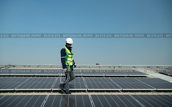 Engineer in charge of solar panel installation The installation of solar energy conversion into electricity for a warehouse is currently being investigated. Стоковое фото, агентство Ingram Publishing / Фотобанк Лори