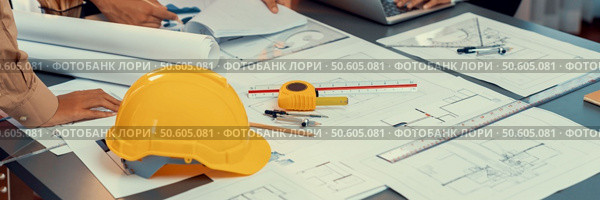 Engineer partner drawing and working on blueprint design together on office table for architectural building construction project. Architect drafting interior blueprint layout. Insight. Engineer partner drawing and working on blueprint design together. Insight. Стоковое фото, агентство Ingram Publishing / Фотобанк Лори