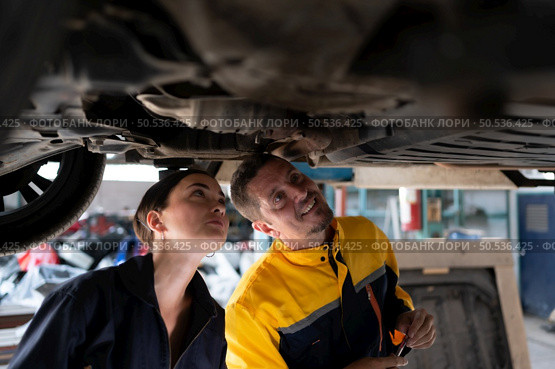Engineers and auto repair technicians must use technology to detect faults in the operation of the engine of customer cars brought to repair in the garage. Стоковое фото, агентство Ingram Publishing / Фотобанк Лори