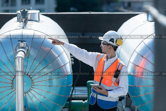 Engineers inspect the completed air conditioning and water systems to continue verifying their functionality. Стоковое фото, агентство Ingram Publishing / Фотобанк Лори