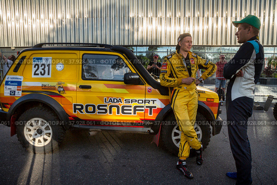 Евгений Загороднюк у автомобиля команды LADA Sport ROSNEFT Raid принимает участие во время торжественной церемонии награждения участников международного ралли "Шелковый путь" в "Лужниках" города Москвы, Россия (2022 год). Редакционное фото, фотограф Николай Винокуров / Фотобанк Лори