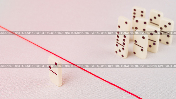 Expelled from the group, unable to cross the red line that separates them. Scene with group of domino. Concept of accusation guilty person, bulling or outcast in the team. Стоковое фото, фотограф Igor Tichonow / Фотобанк Лори