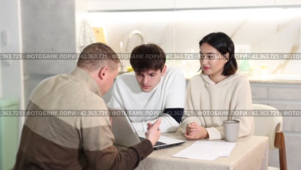 Experienced male agent offers to issue an insurance policy or take out a financial loan for spouses at home. Стоковое видео, видеограф Яков Филимонов / Фотобанк Лори