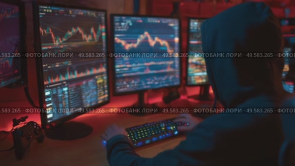 Expert trader analyzes market trends while surrounded by multiple screens in a dark workspace. Стоковое AI-видео, аниматор Сергей Толмачёв / Фотобанк Лори