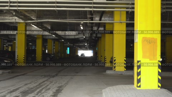 Exploring the Architectural Features of a Modern Parking Garage with Bold Yellow Supports and Clear Sightlines to the Exit. Стоковое видео, видеограф Владимир Федоров / Фотобанк Лори