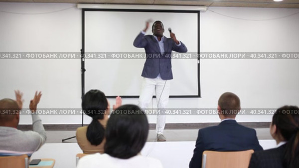 Expressive male lecturer speaking and jumping at corporate motivational coaching and training conference. Стоковое видео, видеограф Яков Филимонов / Фотобанк Лори