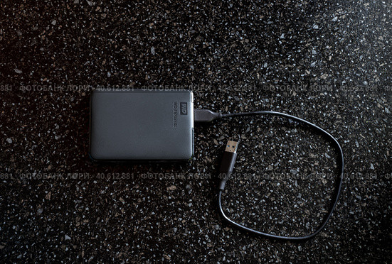 External HDD WD Elements Portable in a black case with a wire on a black background. A useful portable storage device, a portable device with a high data transfer rate. Стоковое фото, фотограф Коханова Наталья / Фотобанк Лори