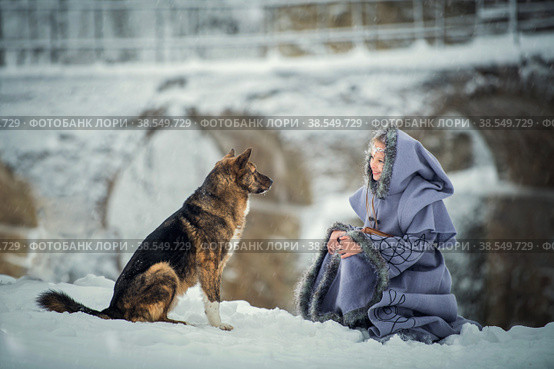 Fabulous girl Elf communicates with the dog against the backdrop of an ancient fortress in winter. Стоковое фото, фотограф Мария Мороз / Фотобанк Лори