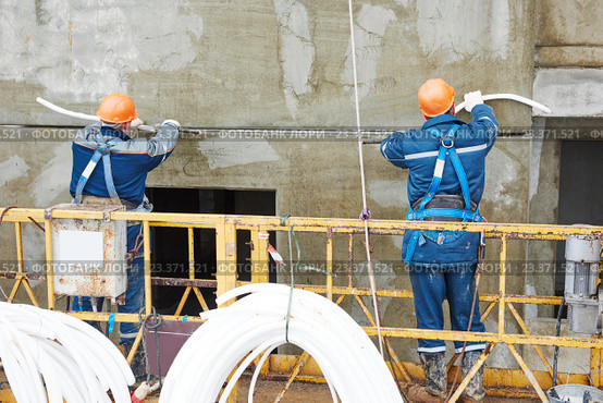Facade plasterers sealing joint of building wall with putty mastic. Стоковое фото, фотограф Дмитрий Калиновский / Фотобанк Лори