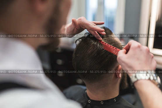 faceless barber combing hair man before cutting. Стоковое фото, агентство Ingram Publishing / Фотобанк Лори