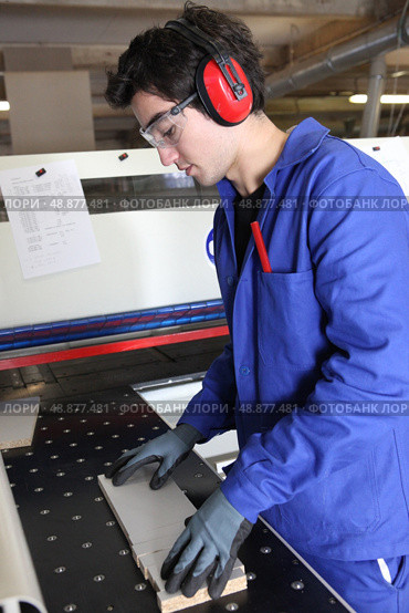 Factory worker wearing ear defenders. Стоковое фото, агентство Ingram Publishing / Фотобанк Лори
