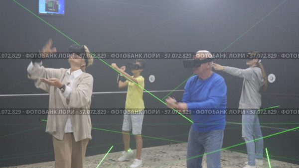 Family are wearing virtual reality goggles in the quest room. Стоковое видео, видеограф Яков Филимонов / Фотобанк Лори