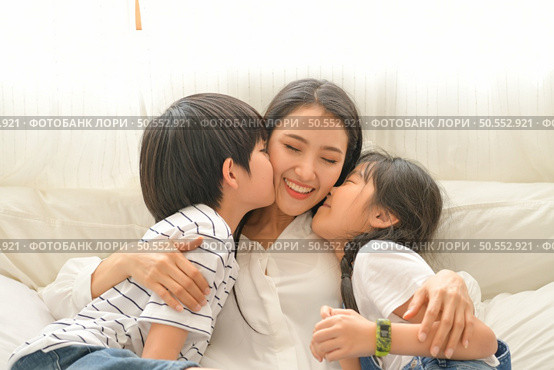 Family happy moments when children wake up in the morning. Have fun with mom before eating breakfast. Стоковое фото, агентство Ingram Publishing / Фотобанк Лори