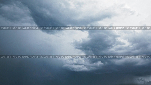 Fast moving dark blue rainy clouds before storm on a background of dramatic sky with lightnings. 4K hyperlapse moving, timelapse. 3840, 2160p.. Dramatic dark blue sky with moving clouds before storm and rain. Стоковое фото, агентство Ingram Publishing / Фотобанк Лори