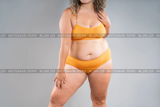 Fat woman in orange underwear on gray background, obesity and cellulite, overweight female body, weight loss concept. Стоковое фото, фотограф Станислав Тарко / Фотобанк Лори