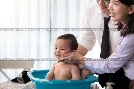 Father and mother bathe their son after they come home from work. Стоковое фото, агентство Ingram Publishing / Фотобанк Лори