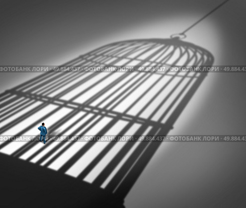 Feeling trapped in a prison concept as a person standing inside the cast shadow of a giant bird cage as a metaphor for business career frustration or human repression metaphor. Стоковое фото, агентство Ingram Publishing / Фотобанк Лори