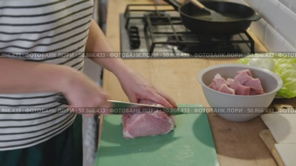 Female butcher cut raw meat with sharp knife at home kitchen. Woman cutting the chicken fillet in pieces for cooking. Preparing chopping food. Split poultry breast. Healthy lean meat, low cholesterol. Стоковое видео, видеограф Марина Демидюк / Фотобанк Лори
