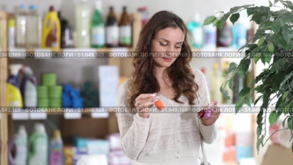 Female client in store selects nail polish for allergy sufferers, studies instructions for use on label. Client see over good in household shop. Стоковое видео, видеограф Яков Филимонов / Фотобанк Лори
