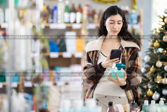 Female client scanning QR code on package tile cleaner spray. Стоковое фото, фотограф Яков Филимонов / Фотобанк Лори