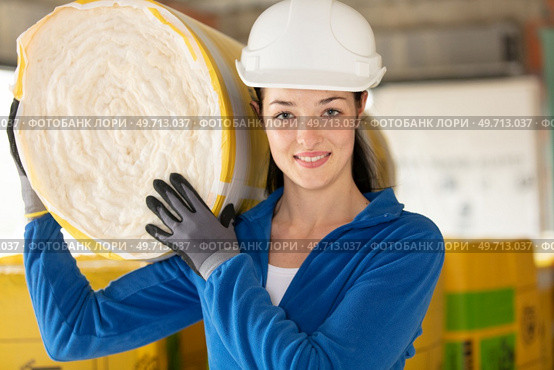 female construction worker with roll of insulating material. Стоковое фото, агентство Ingram Publishing / Фотобанк Лори