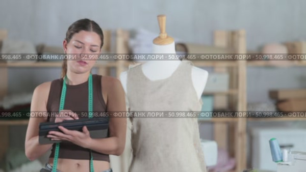 Female fashion designer drawing clothing on tablet in studio. Стоковое видео, видеограф Яков Филимонов / Фотобанк Лори