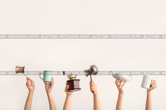 Female hands with coffee grinder, jezve, teapot and cups on light background. Стоковое фото, фотограф Pixel_shot / Фотобанк Лори