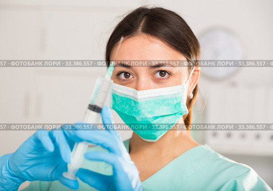 Female nurse in mask holding syringe for injection in hospital. Стоковое фото, фотограф Яков Филимонов / Фотобанк Лори