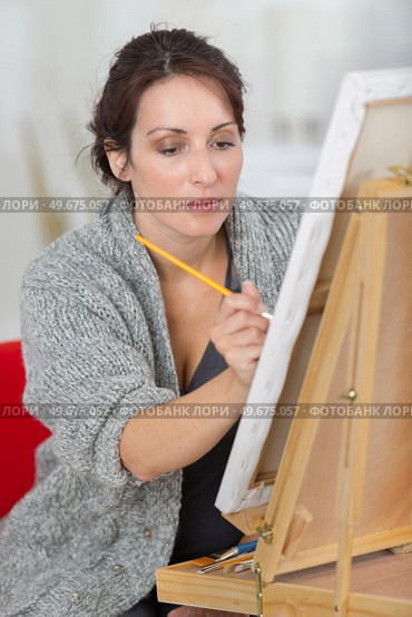 female painter drawing in art studio using easel. Стоковое фото, агентство Ingram Publishing / Фотобанк Лори