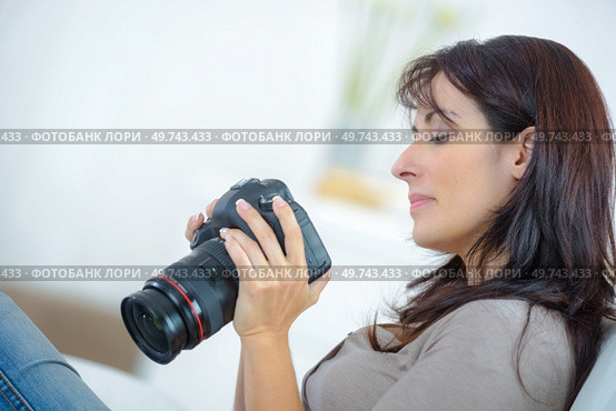 female photographer checking picture in camera. Стоковое фото, агентство Ingram Publishing / Фотобанк Лори