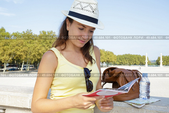 female tourist checking guide. Стоковое фото, агентство Ingram Publishing / Фотобанк Лори