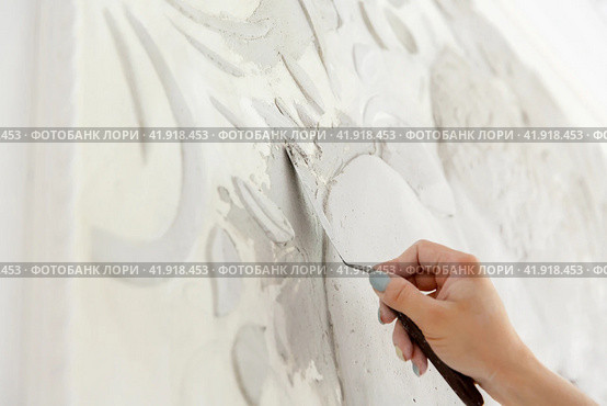 Female worker puts putty mortar on a wall with a bas-relief. Стоковое фото, фотограф Aleksandra Selivanova / Фотобанк Лори