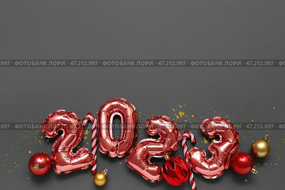Фигура 2023 из фольгированных шаров с новогодним декором на черном фоне. Стоковое фото, фотограф Pixel_shot / Фотобанк Лори