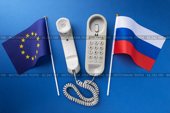 Flag of the European Union, Russia and an old corded telephone on a blue background, concept on the topic of telephone conversations. Стоковое фото, фотограф Сергей Чайко / Фотобанк Лори