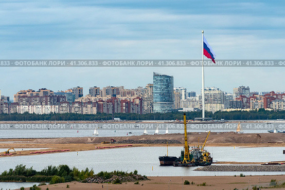 Флаг Российской Федерации на 175-метровом флагштоке возле Финского залива и парка 300-летия Санкт-Петербурга. Вид со стороны намывных территорий Васильевского острова (2023 год). Редакционное фото, фотограф Румянцева Наталия / Фотобанк Лори