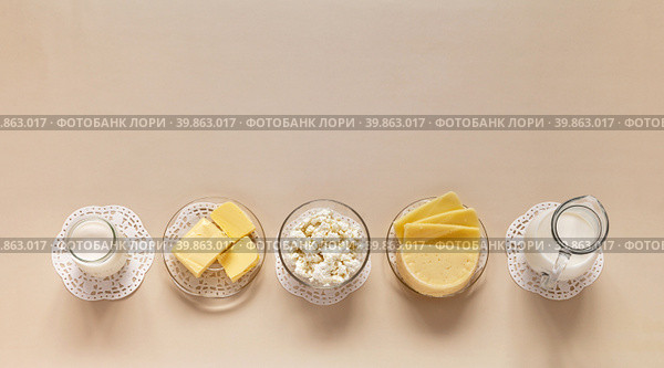 Flat lay of fresh dairy products - milk, cottage cheese, yogurt, sour cream and butter on light pastel background. Organic farm natural healthy food. Empty space for text. Top view, closeup, mock up. Стоковое фото, фотограф Виктория Катьянова / Фотобанк Лори