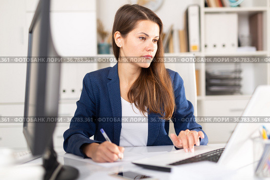 Focused business woman working with laptop and documents. Стоковое фото, фотограф Яков Филимонов / Фотобанк Лори