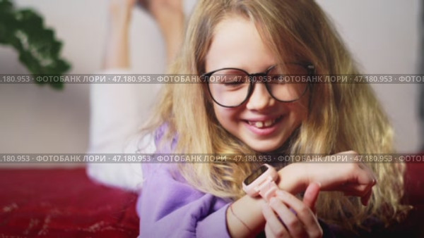 Focused child using smart watch for homework reminders, time management, and study assistance. Concept of digital tools improving education, student productivity, and smart learning solutions. Стоковое видео, видеограф Енваев Андрей / Фотобанк Лори