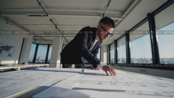 Focused Professional Analyzing Architectural Plans in Modern Office Space with Cityscape View, Showcasing Commitment to Design and Attention to Detail. Стоковое AI-видео, аниматор Владимир Федоров / Фотобанк Лори