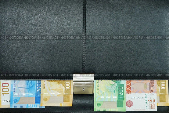 Фон. Черный кожаный портфель с металлическим замком. Российские денежные купюры торчат из-под крышки. Стоковое фото, фотограф Цибаев Алексей / Фотобанк Лори
