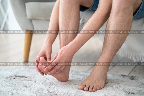 Foot pain, corns and calluses, dry skin on legs, man suffering from feet ache, podiatry concept. Стоковое фото, фотограф Станислав Тарко / Фотобанк Лори