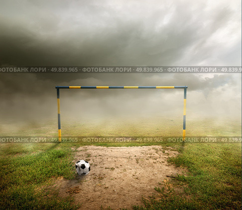 Football field, football goal, deflated ball and cloudy sky. Стоковое фото, агентство Ingram Publishing / Фотобанк Лори