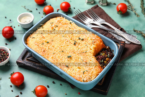 Форма для выпечки с вкусным пастушьим пирогом на зеленом фоне. Стоковое фото, фотограф Pixel_shot / Фотобанк Лори