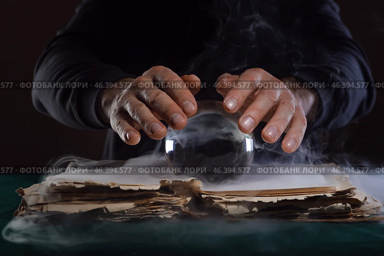 Fortune teller with crystal ball and book at table. Стоковое фото, фотограф Pixel_shot / Фотобанк Лори