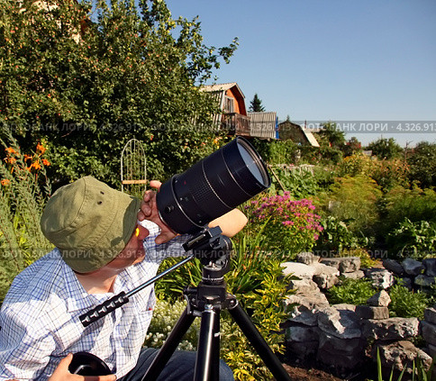 Фотограф настраивает телеобъектив на штативе готовясь к съёмке солнца. Солнечное ,,Русское,, затмение. 1 августа 2008 года район города Бердска Новосибирской области. Стоковое фото, фотограф Евгений Мухортов / Фотобанк Лори