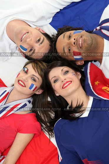 Four young adults supporting the French soccer team. Стоковое фото, агентство Ingram Publishing / Фотобанк Лори