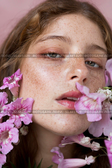 freckled woman holding pink flower. Стоковое фото, агентство Ingram Publishing / Фотобанк Лори