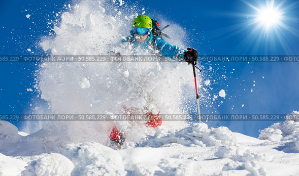 Freeride skier with rucksack running downhill in freeze motion of snow powder.. Freeride skier on piste running downhill. Стоковое фото, агентство Ingram Publishing / Фотобанк Лори